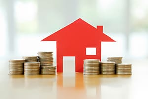 Image of house with stacks of coins around it
